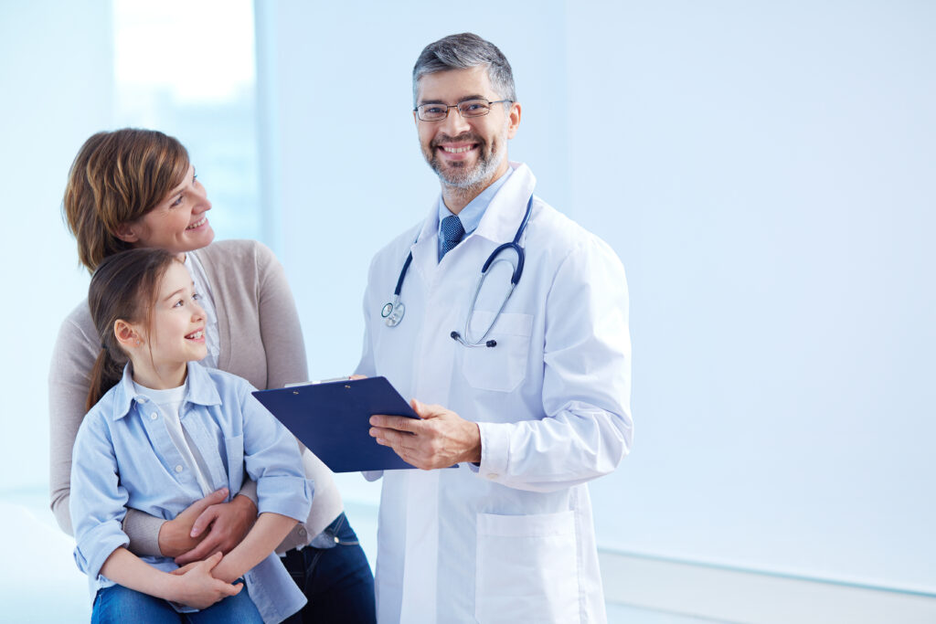 Cute girl and her mother looking at the doctor in hospital, in helath insurance office